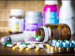 Verschiedene Medikamente und Nahrungsergänzungsmittel, darunter Tabletten, Kapseln, eine Spritze u
